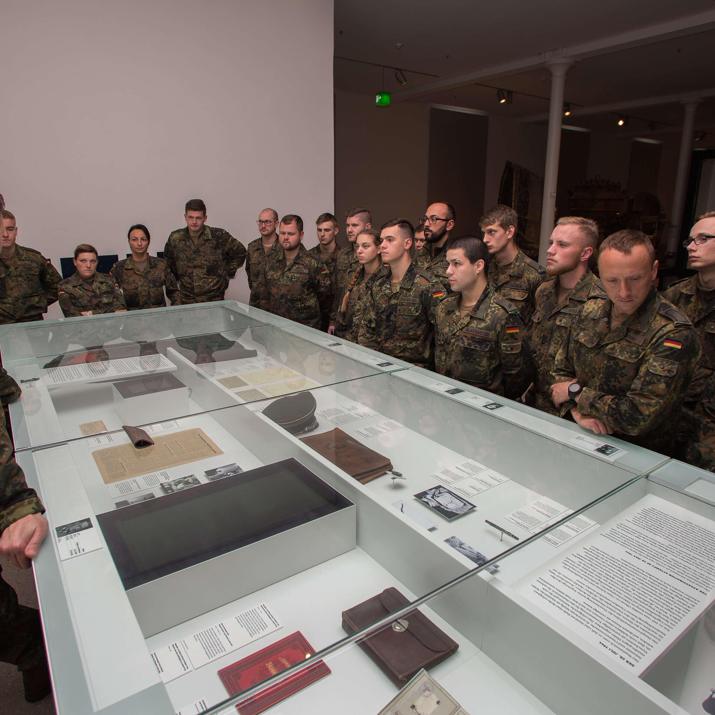 Das Bild zeigt eine Gruppe Soldaten, die um eine Vitrine stehen.