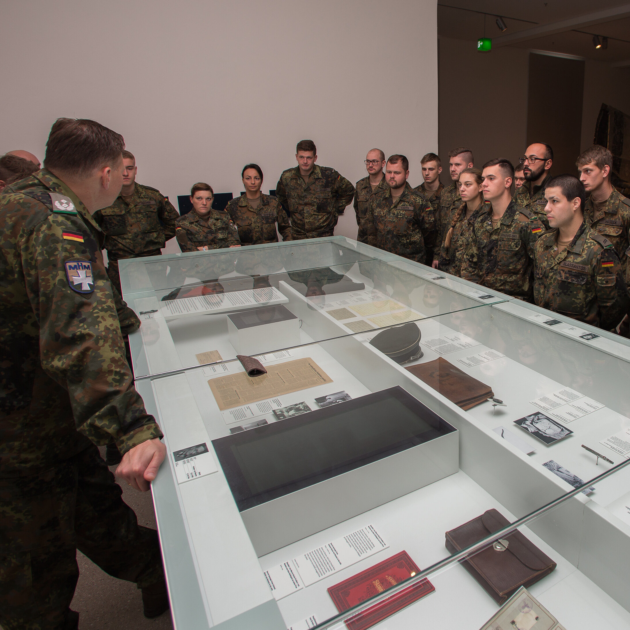 Das Bild zeigt eine Gruppe Soldaten, die um eine Vitrine stehen.