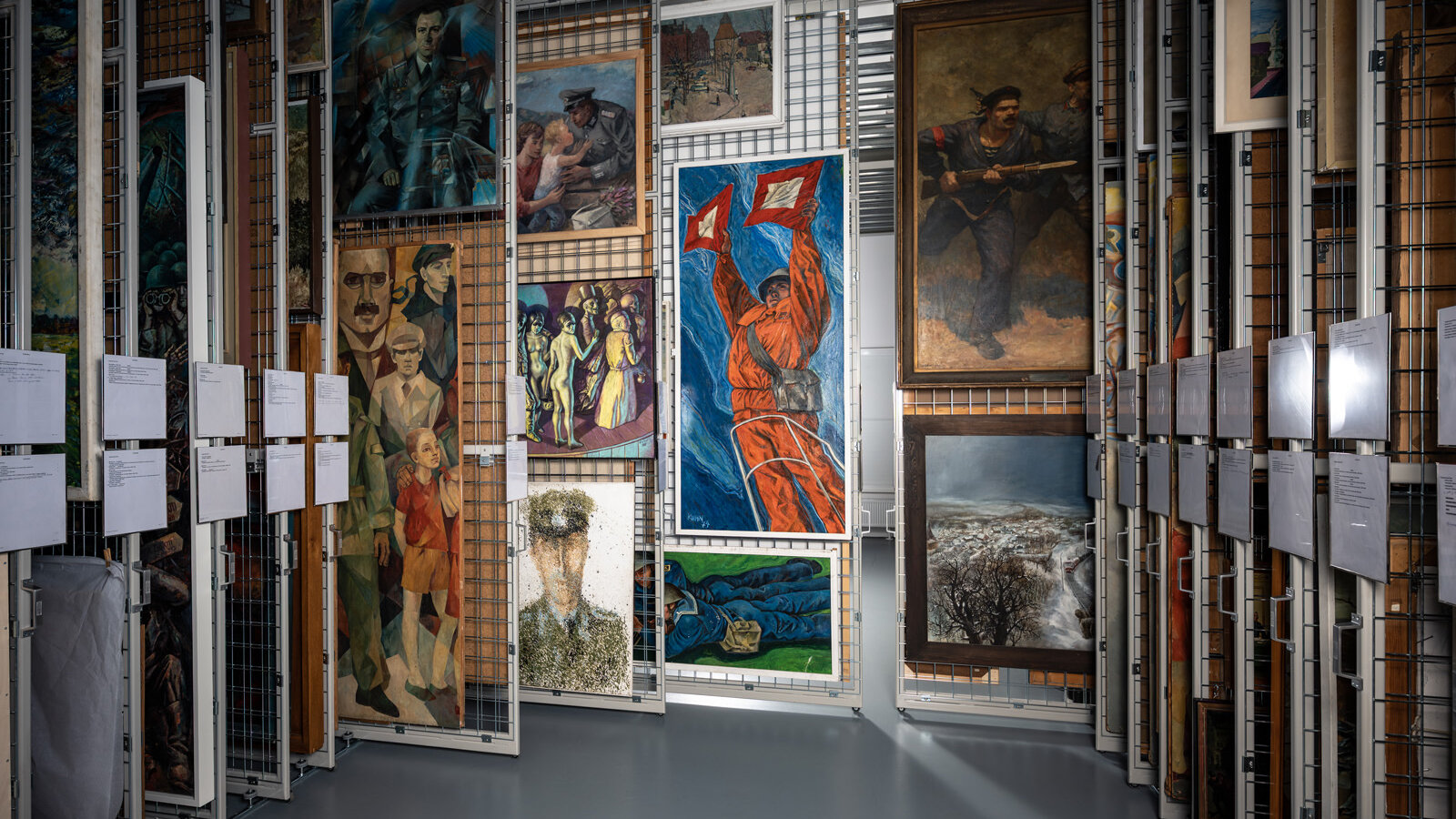 Blick in ein Gemäldedepot. Auf Gitterwänden hängen Werke von Paul Michaelis, Karlheinz Kuhn, Gerda Lepke und anderen.   