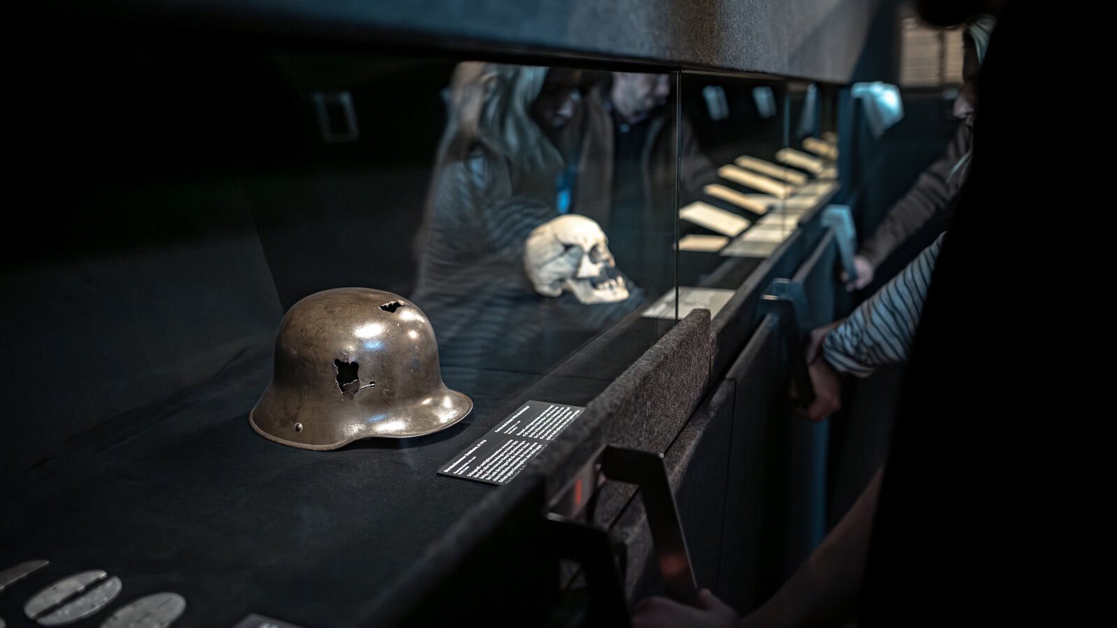 Visitors opening the screen in front of the display cases in the ‘Suffering caused by war’ section. 