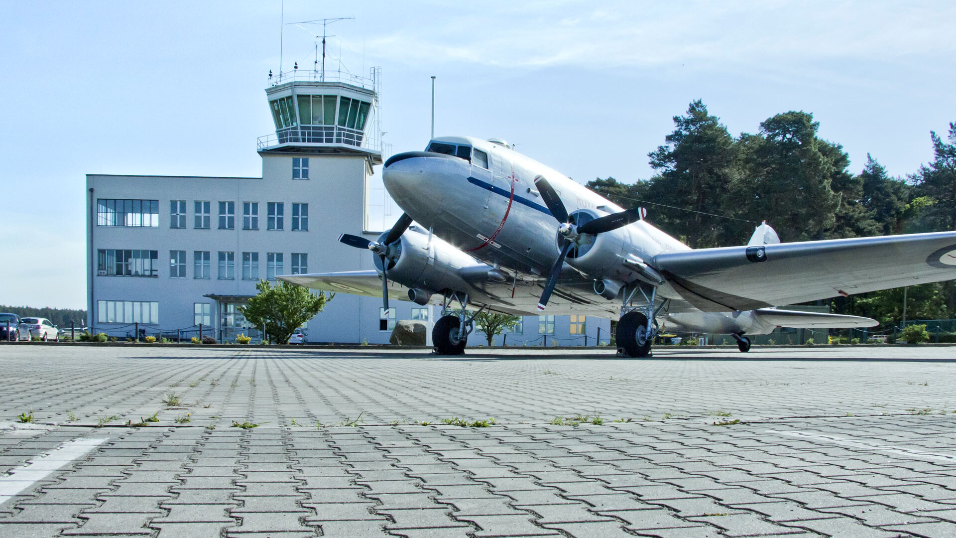 Auf dem Bild ist ein Flugzeug vor dem Towergebäude zu sehen.