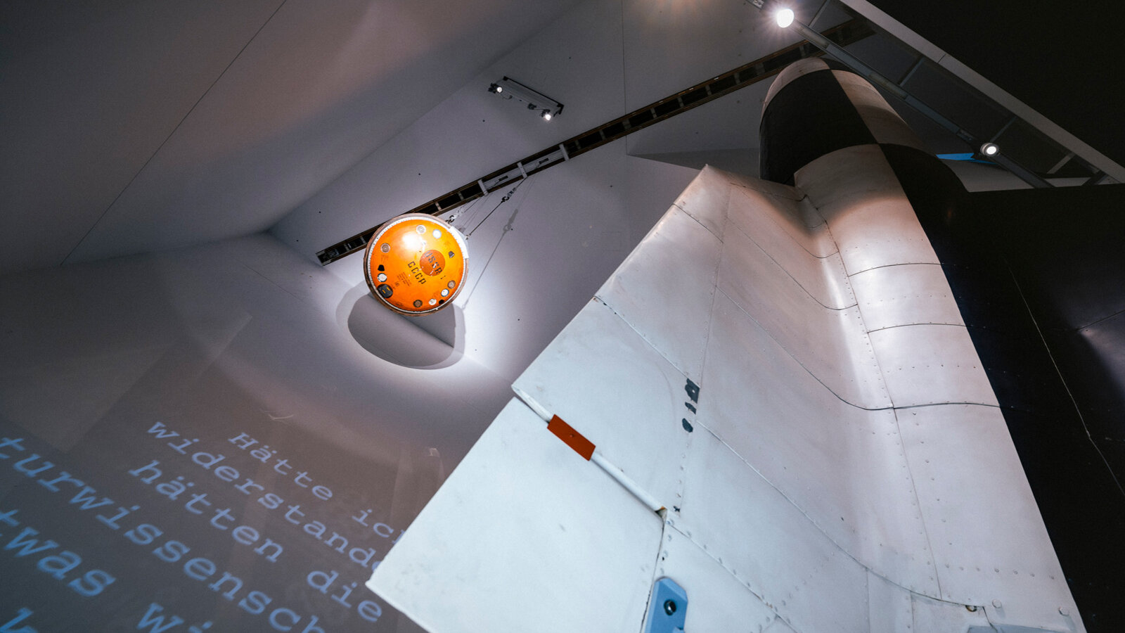Auf der Aufnahme sind eine Raumfahrtkapsel und eine V2-Rakete zu sehen. 