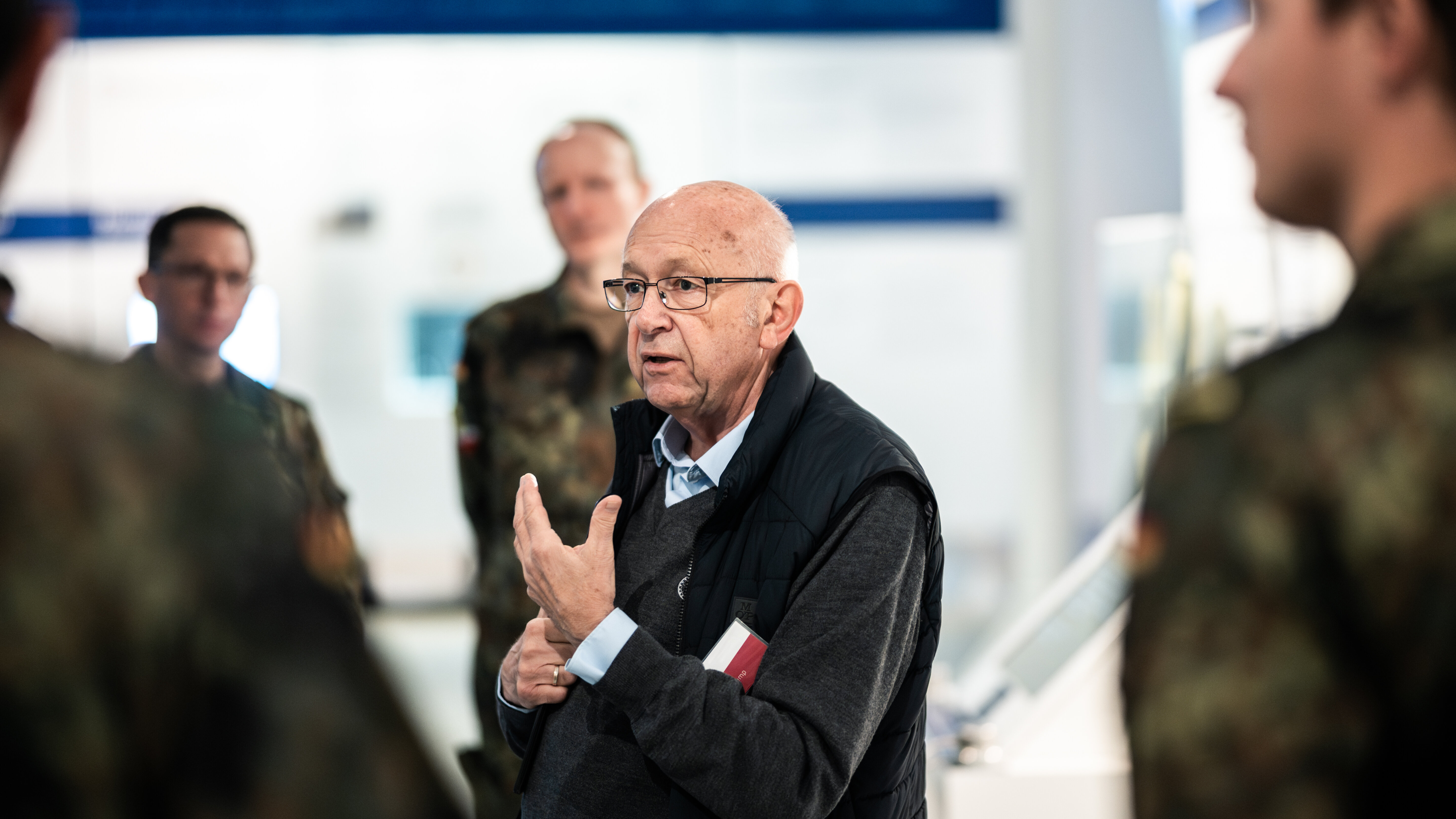 Ein Mann steht vor einer Gruppe von Soldaten und führt durch die Ausstellung. 