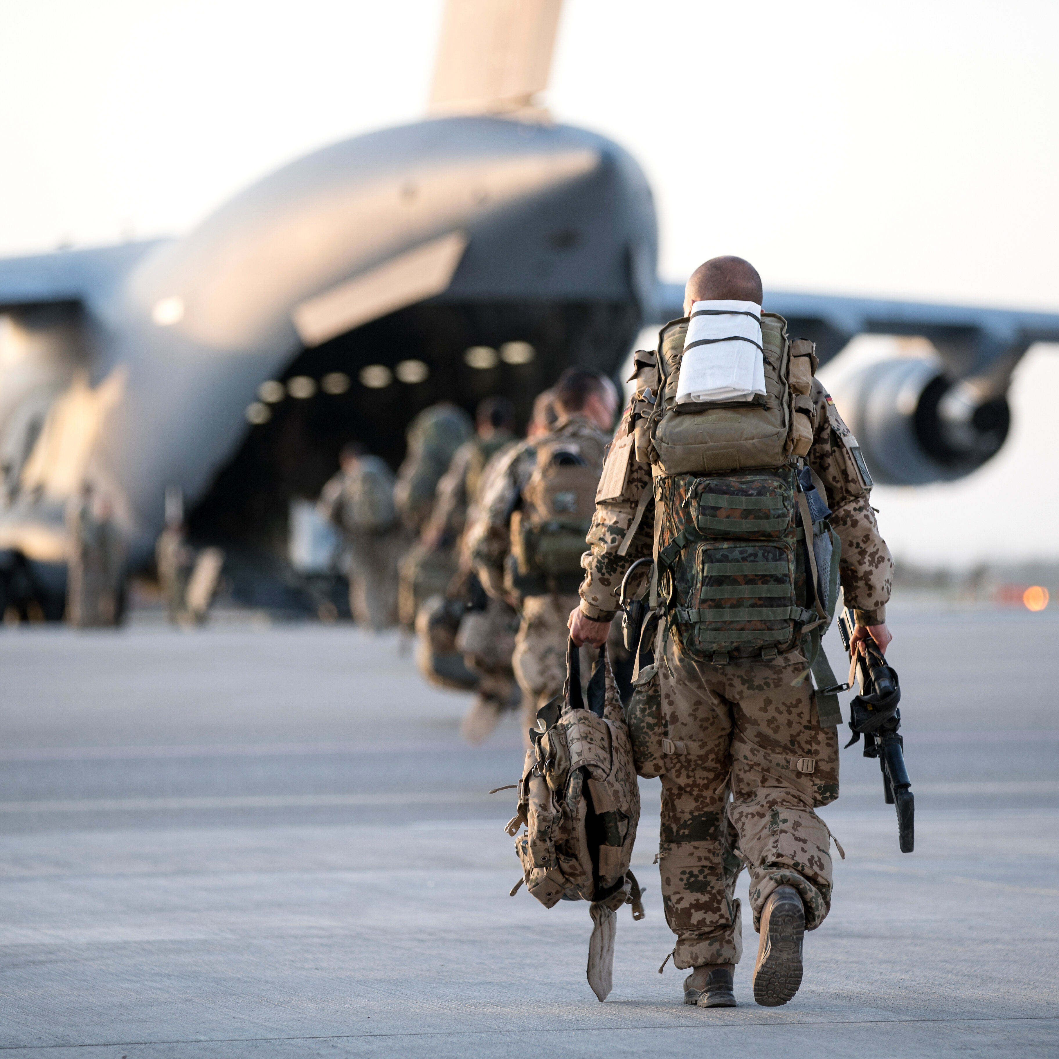 Das Bild zeigt Soldaten, die zu einem Transportflugzeug laufen.