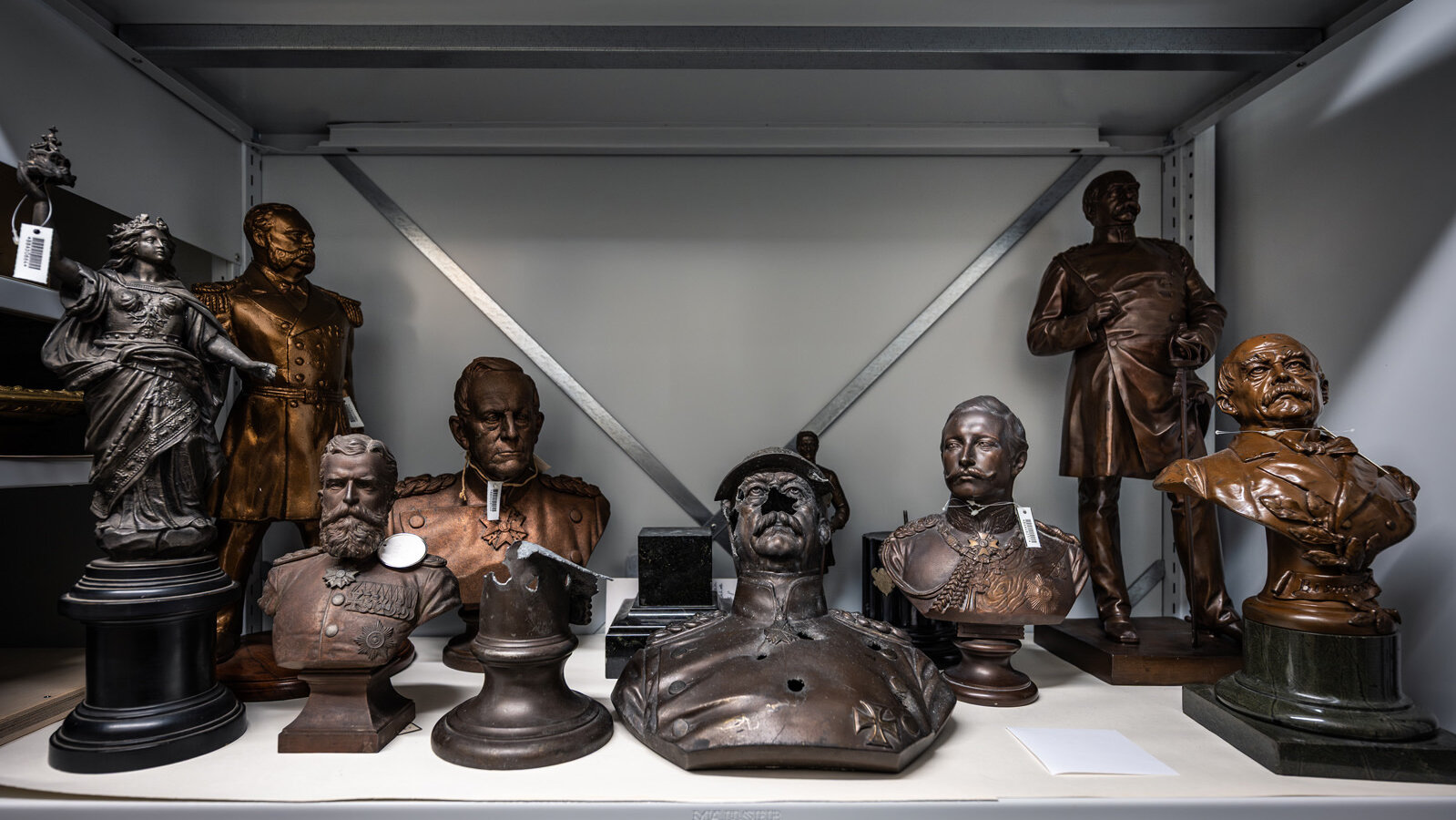 Shelf with several small sculptures, including a statuette of Germania and busts of the politician and statesman Otto von Bismarck. 