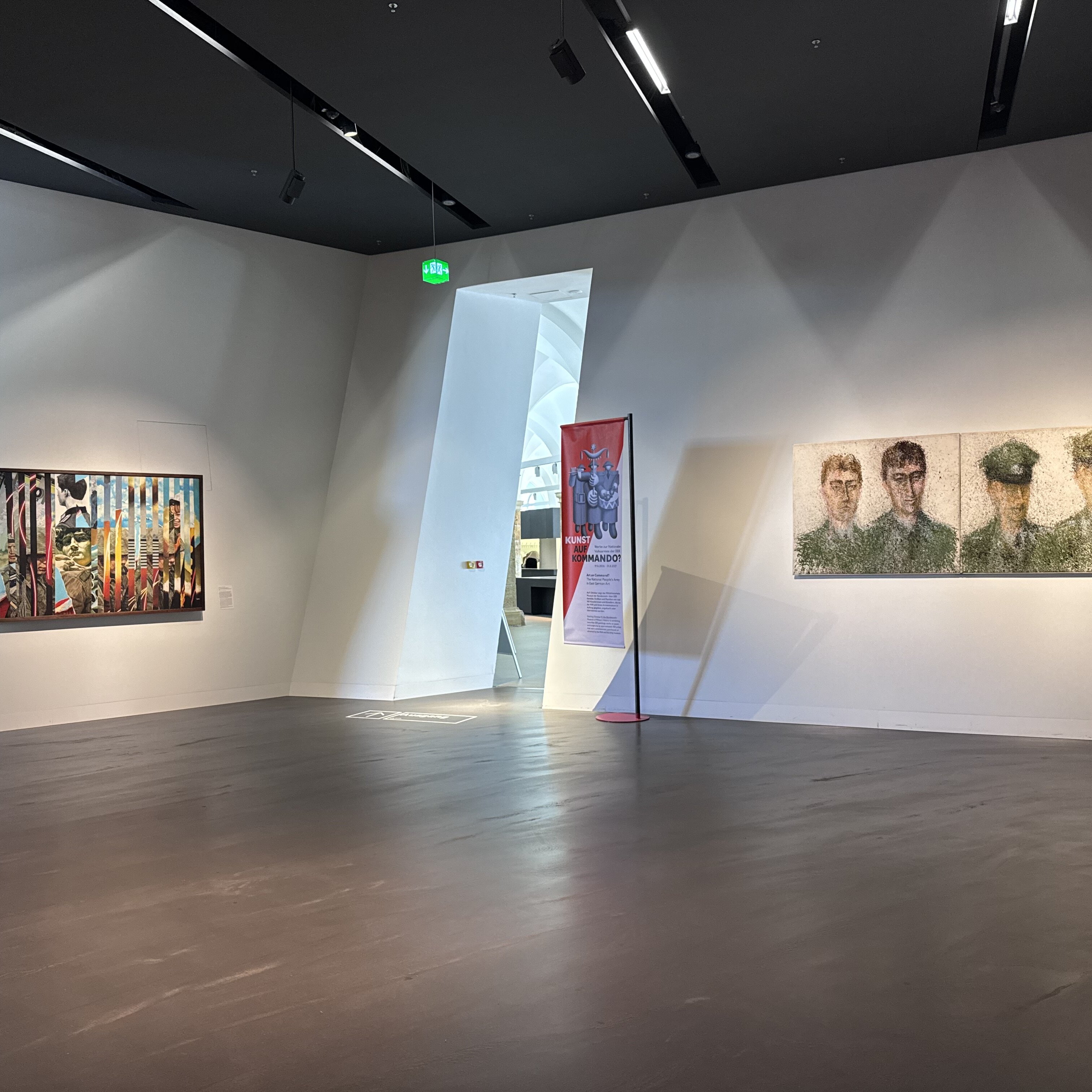 Das Bild zeigt zwei der vier großformatigen Werke, die im Eingangsbereich des Militärhistorischen Museums der Bundeswehr zu sehen sind.