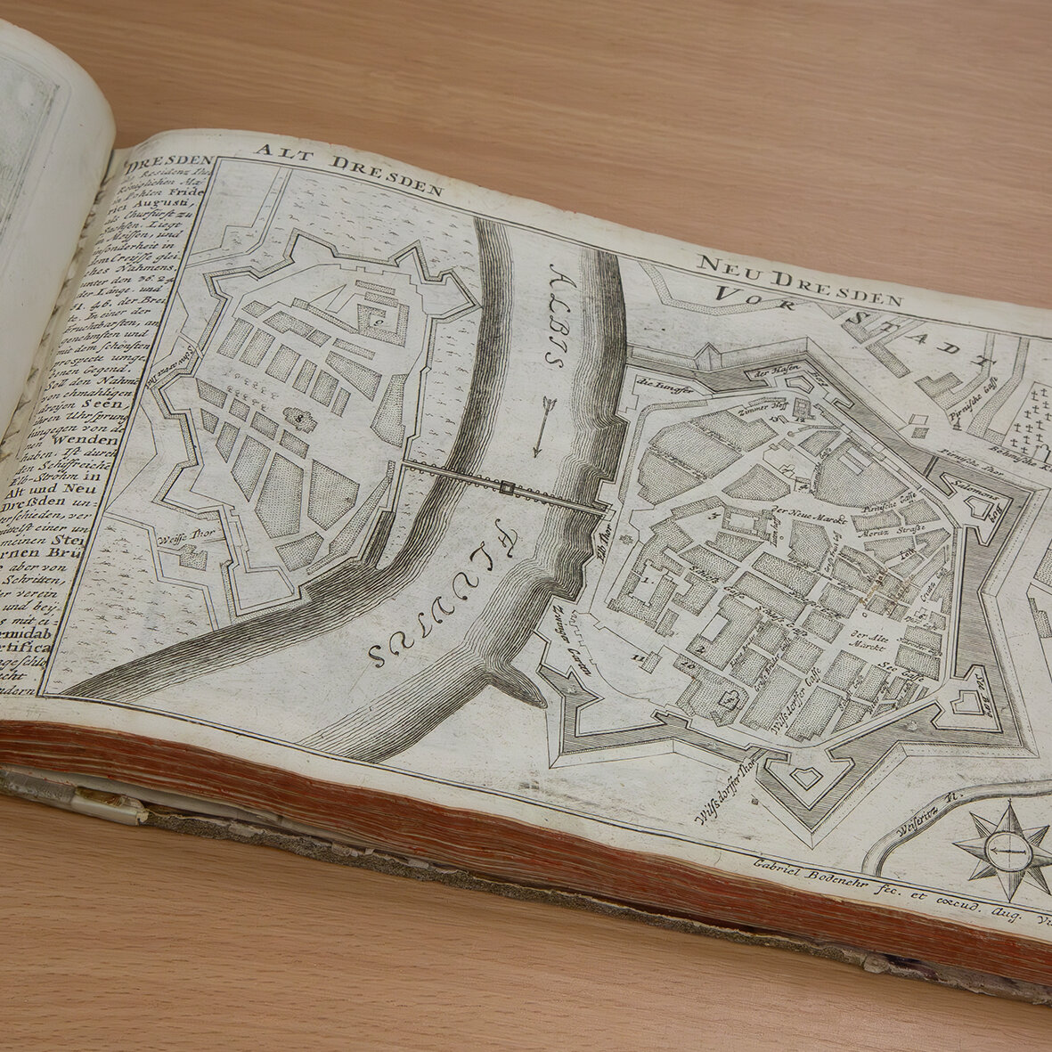 Das Bild zeigt ein aufgeschlagenes Buch um die Zeit von 1730 mit einem Plan von Dresden. 
