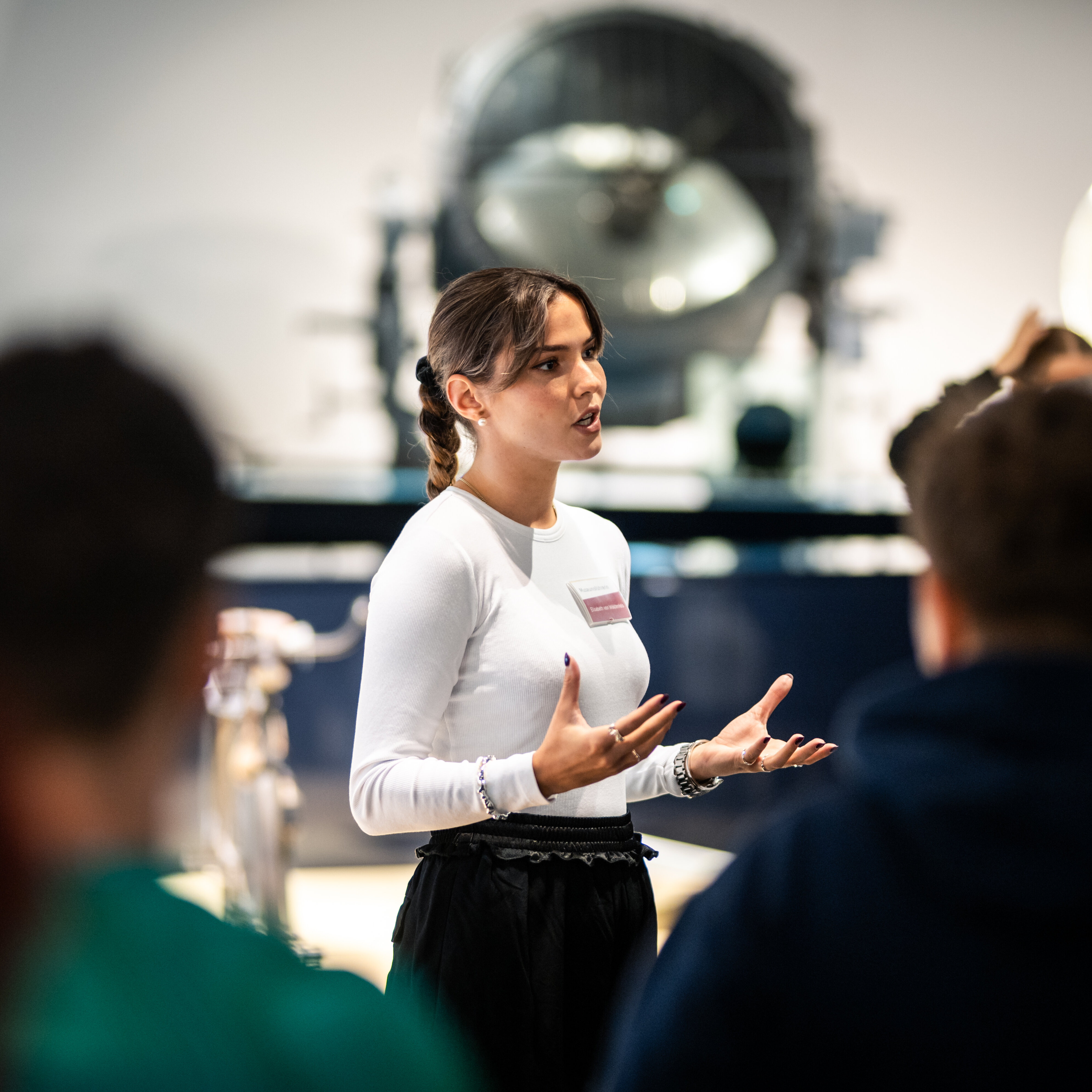 A female guide explains the ‘Military and technology’ section of the permanent exhibition to a group. 