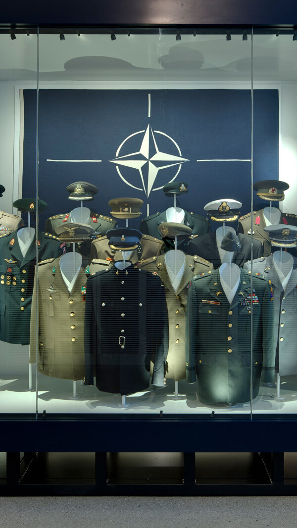 Display case on NATO with uniforms from different member countries. 