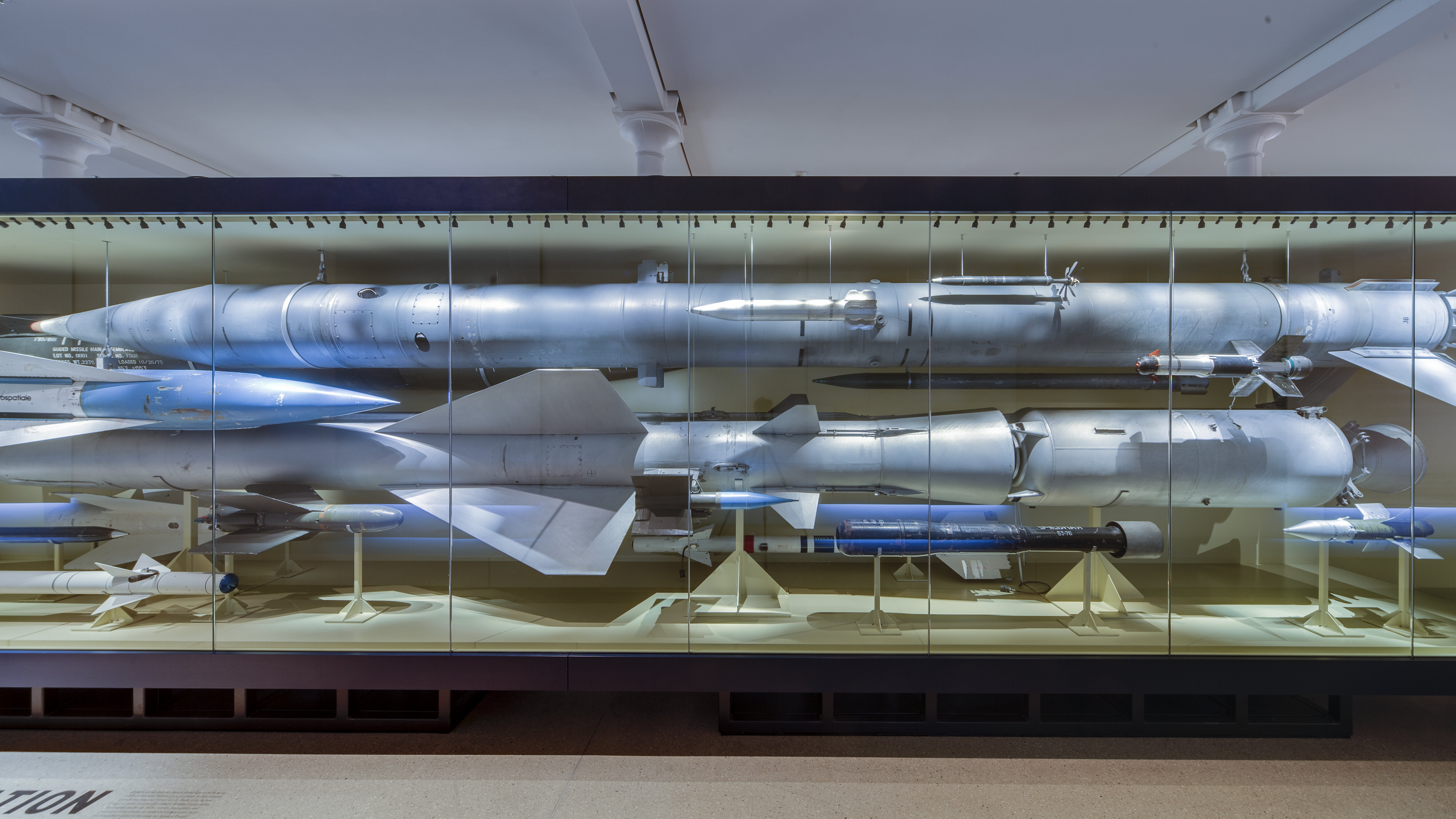In einer großen Vitrine sind verschiedene Raketentypen der NATO und des Warschauer Paktes aufeinander gerichtet. 