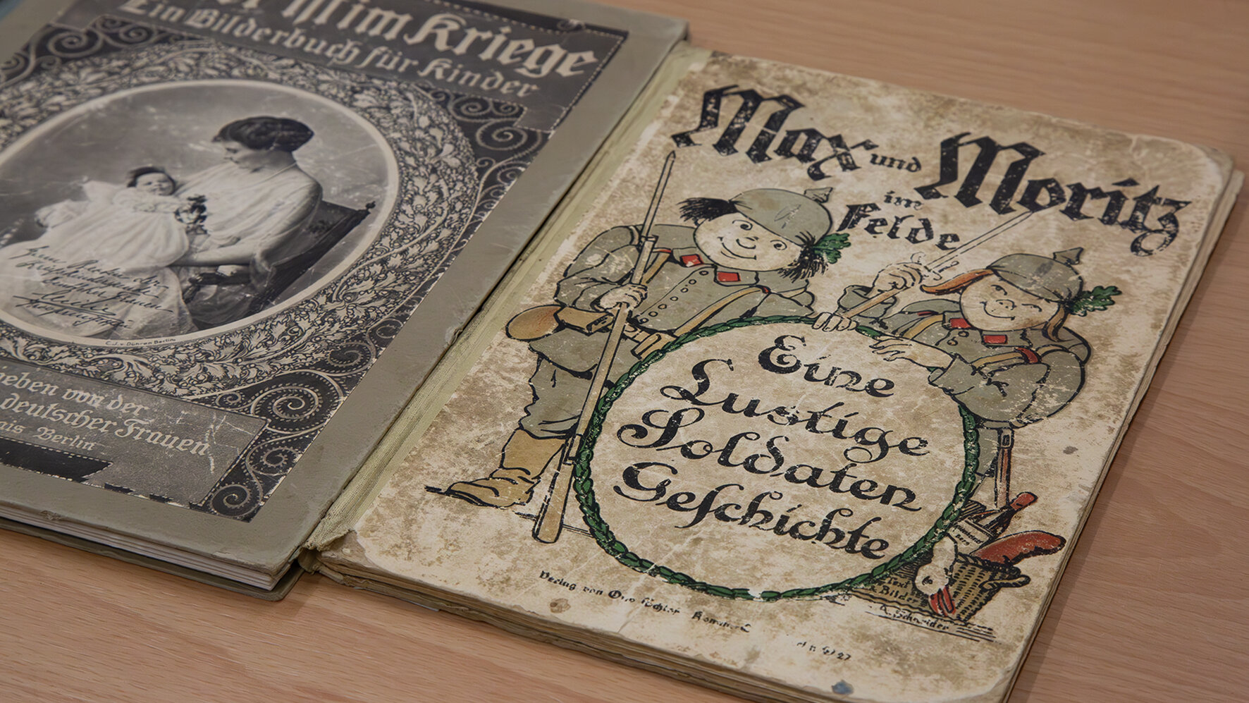 Das Bild zeigt zwei Kinderbücher aus der Zeit des ersten Weltkrieges aus dem Bestand des Militärhistorischen Museums.  